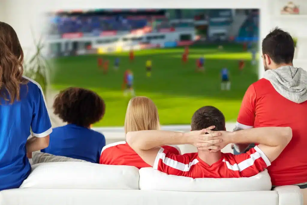 Supporters suivant un match de football grâce à un abonnement IPTV sport premium.